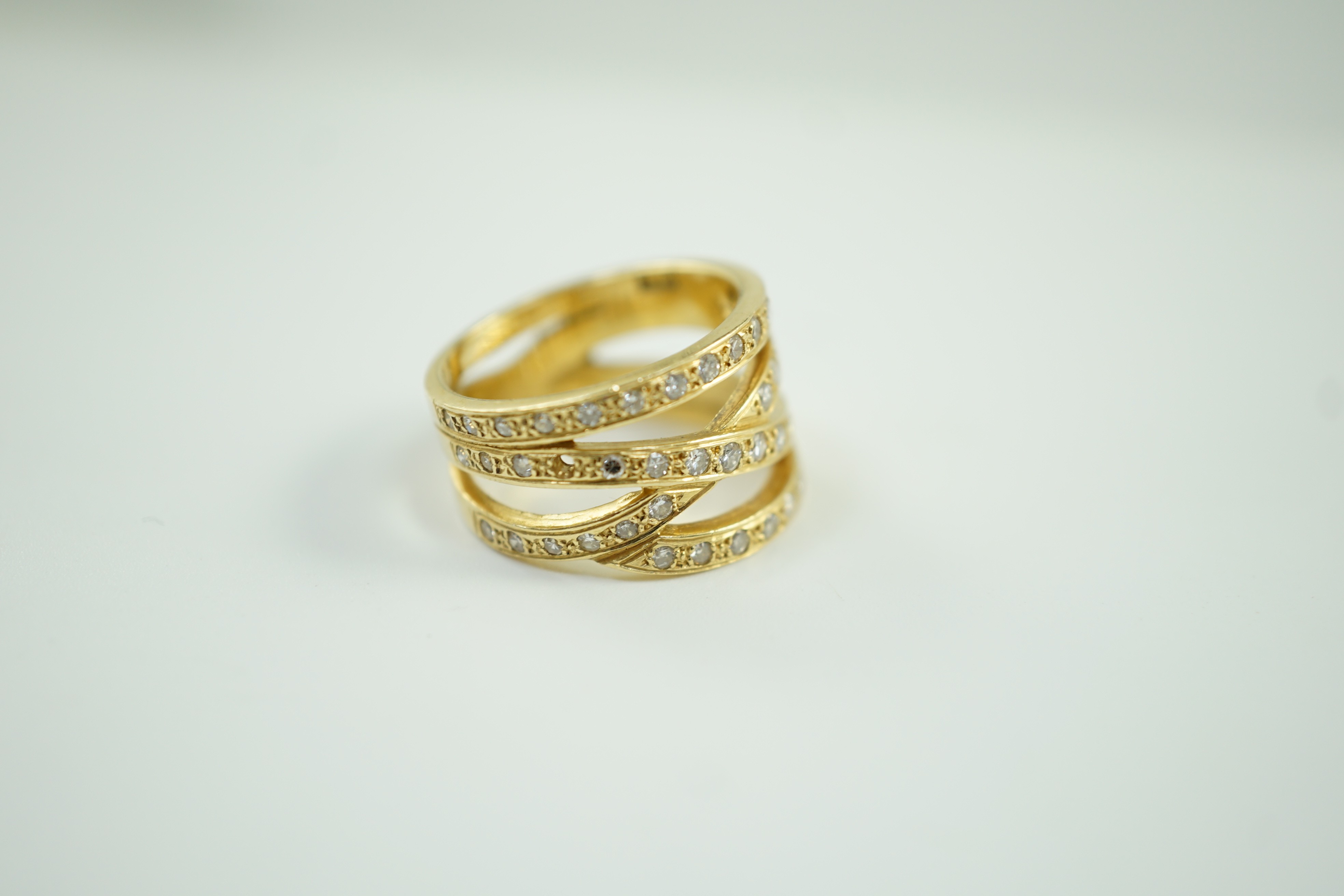 A modern 750 and diamond chip cluster set multi shank dress ring, size P, gross 10.1 grams.